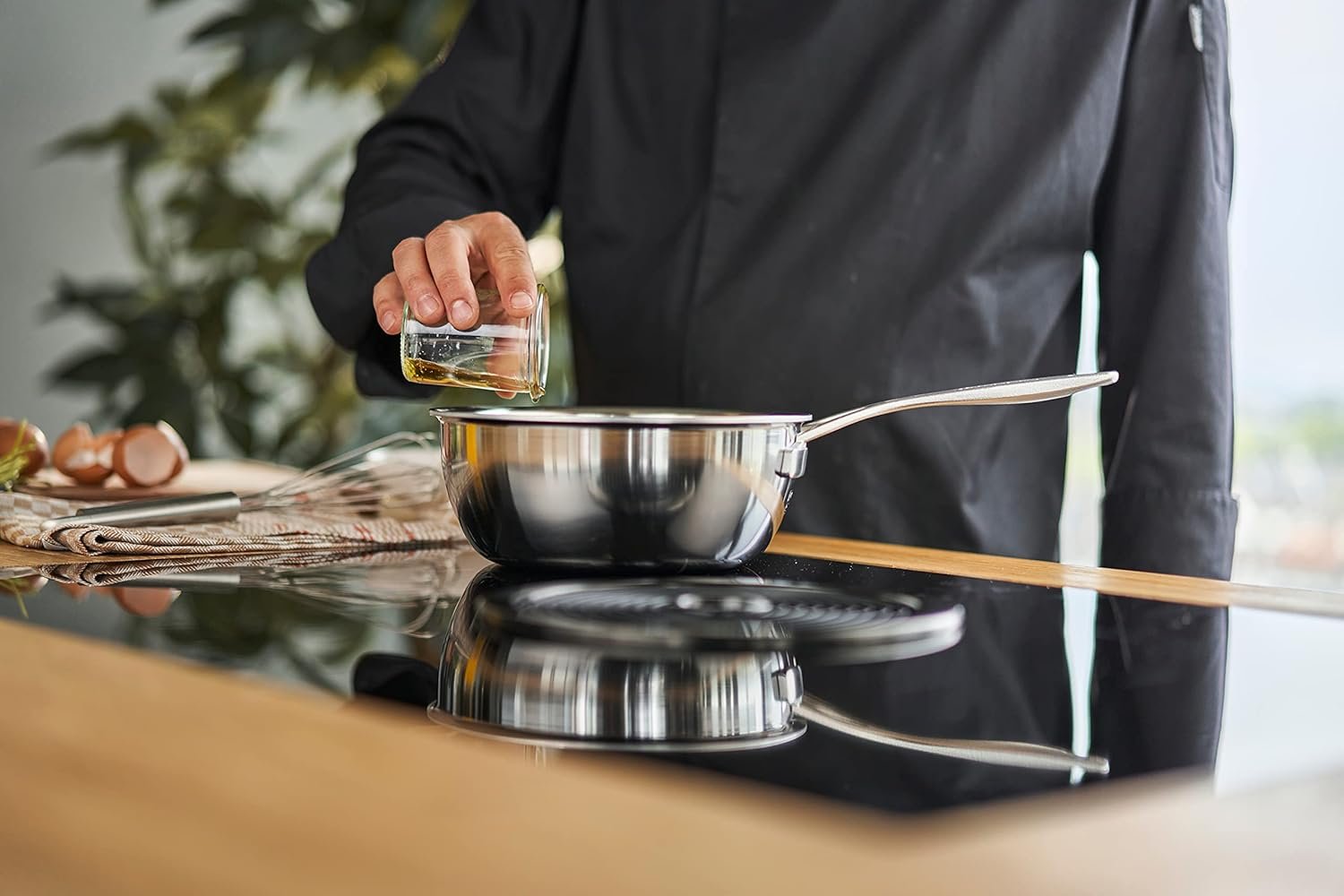 Demeyere Essential 5 — sartén sauté de 3.5 qt (9.5″) de acero inoxidable de 5 capas, con tapa, sobre la estufa.