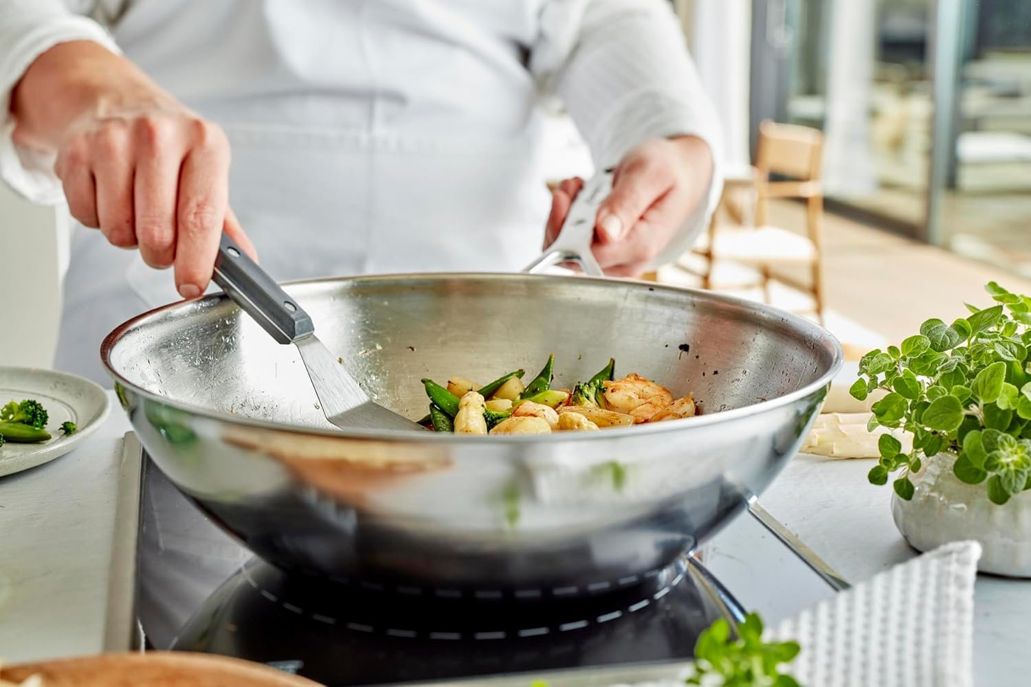 Wok Demeyere Industry 12.6″/32 cm de acero 18/10, 5-ply, fondo plano y asas soldadas, salteando verduras en cocina; apto para inducción.