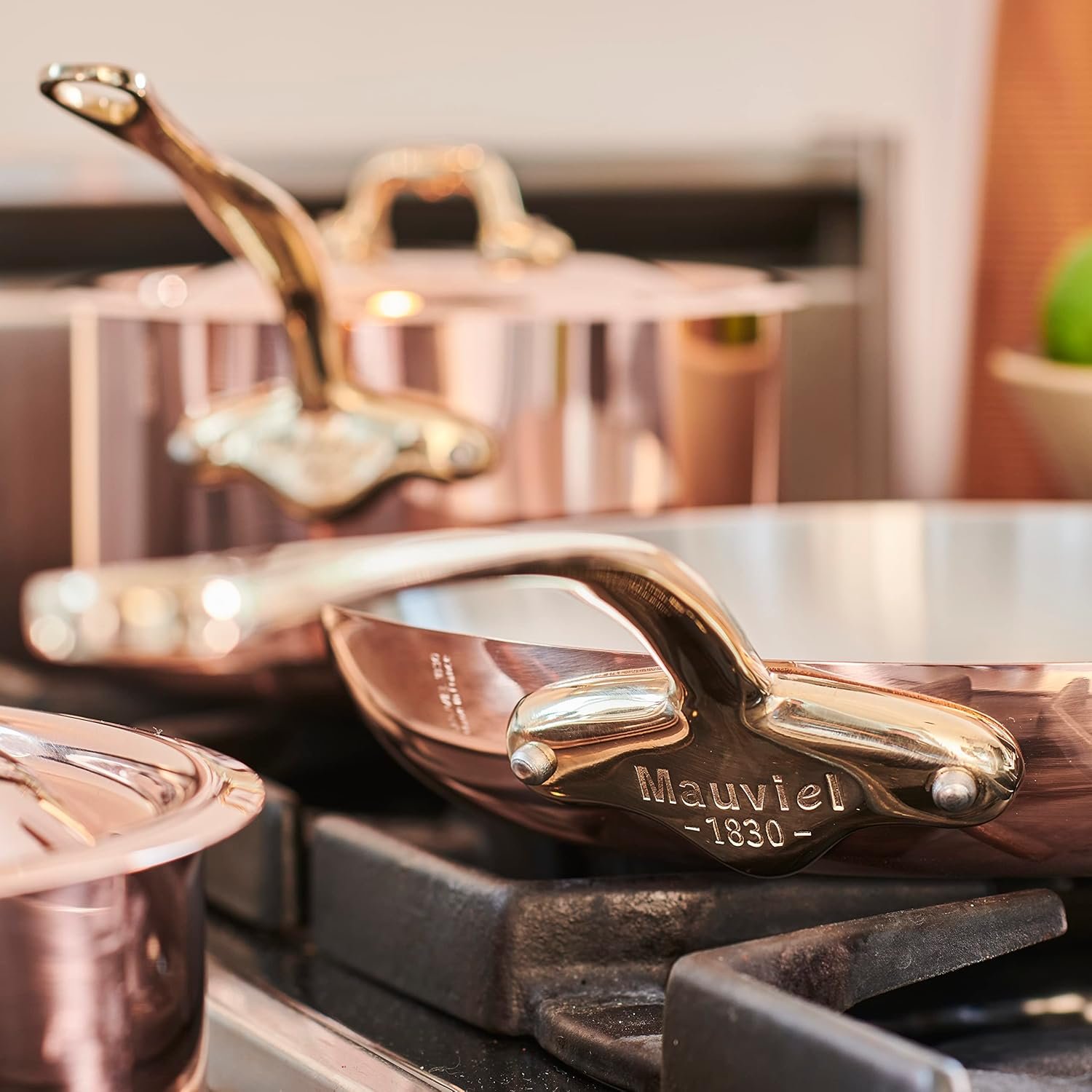 Sartenes de lujo y ollas Mauviel de bronce sobre cocina