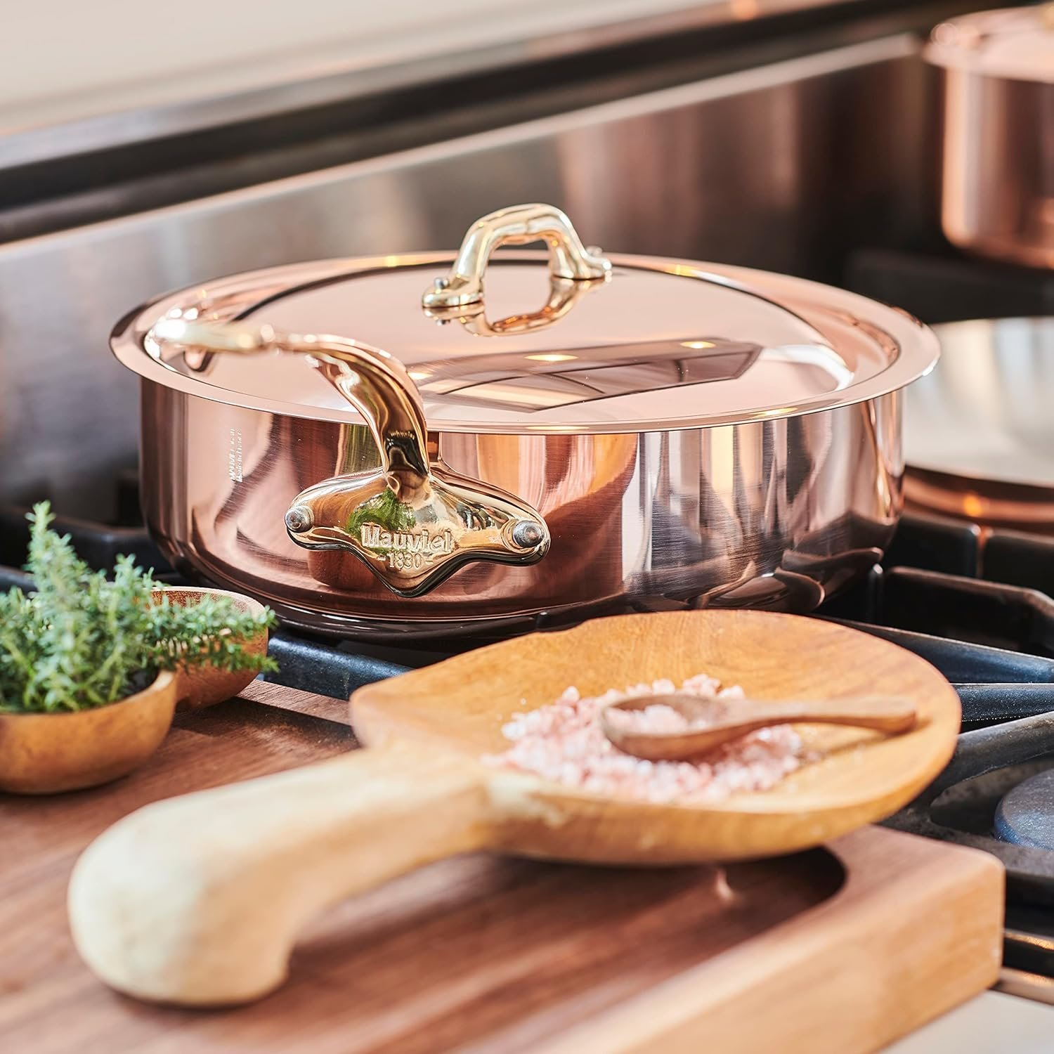Olla Mauviel sobre cocina con utensilios de madera al lado